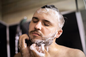 Bearded Man Washes His Beard which is essential to men's beard care.